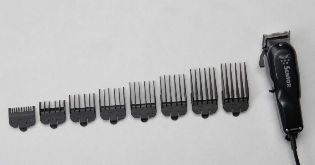 Row of numbered clipper guard attachments arranged from shortest to longest next to a pair of hair clippers