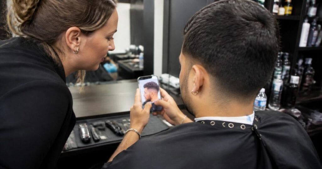 Client showing a reference photo to a barber to explain a mid fade haircut request